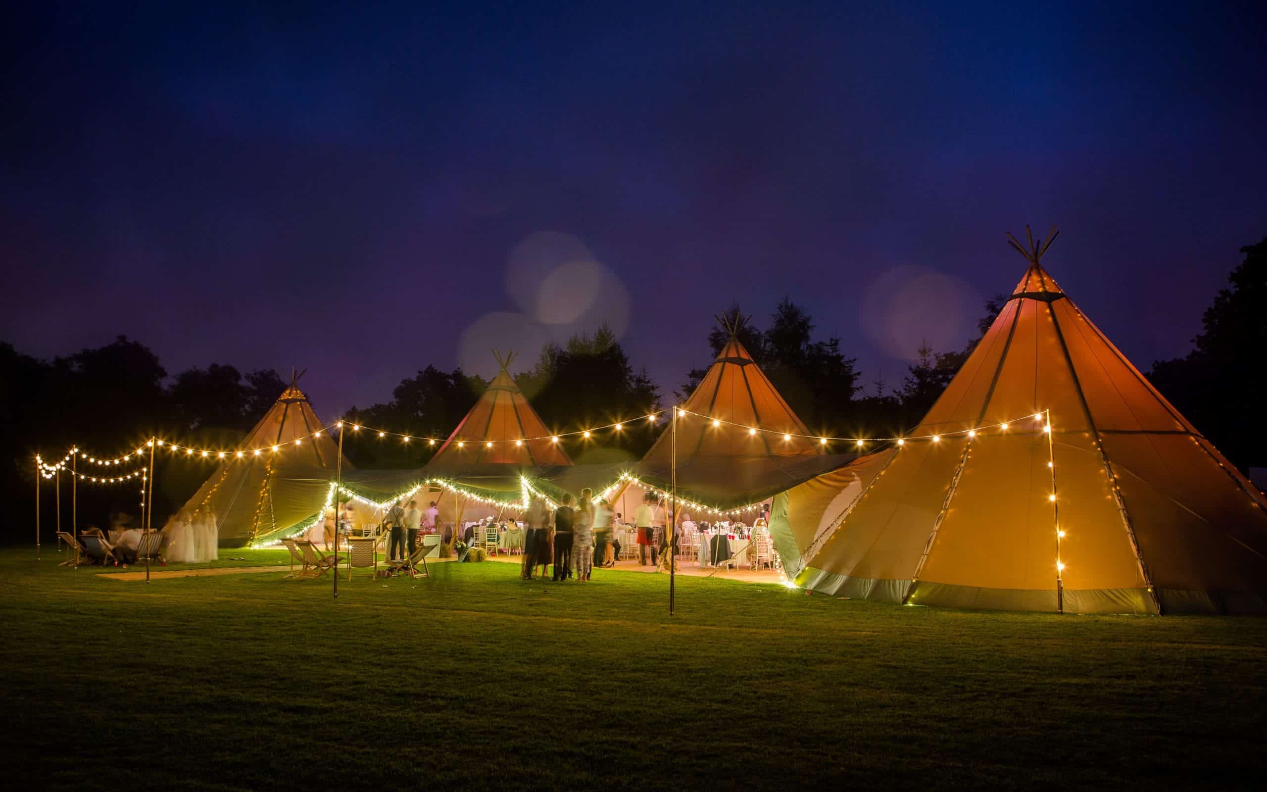 Elite Tents Tipi's on a farm in Warwickshire - lit up at night.