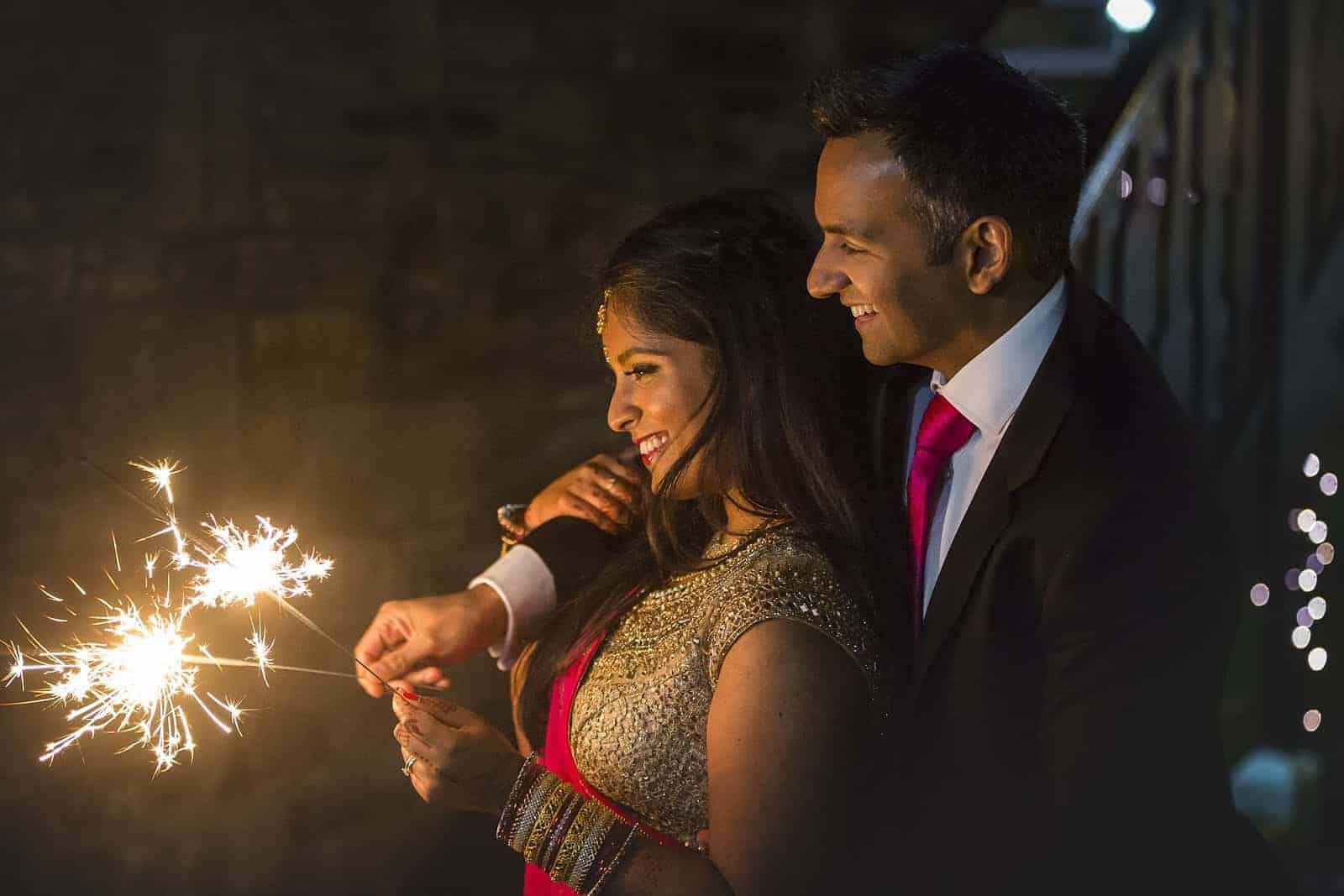 top tips for a perfect sparkler tunnel - bride and groom playing with sparklers